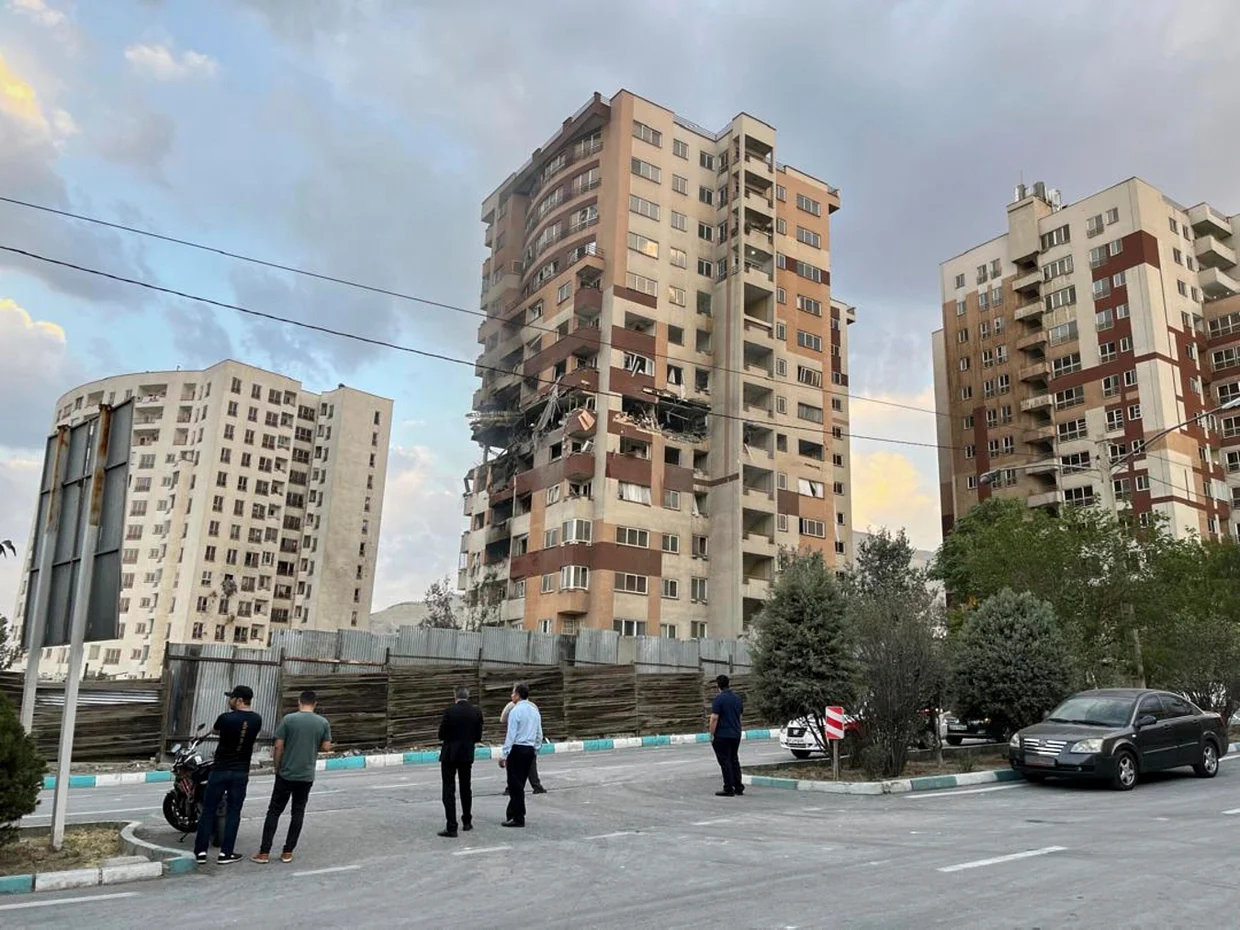 Οι κάτοικοι παρακολουθούν ένα κατεστραμμένο διαμέρισμα στην Τεχεράνη νωρίς την Παρασκευή.Vahid Salemi / AP